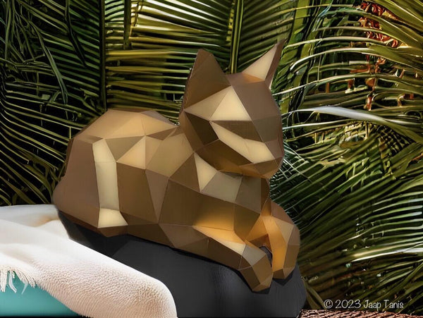 Door Jaap Tanis gebouwde gouden liggende kat met pootjes voor tussen palmbladeren, foto copyright 2023 Jaap Tanis