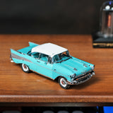 Het 1957 Chevy metalen bouwpakket van SlimSpul nederland b.v. is een klein turquoise en wit model autootje met chromen details. Het staat op hout en roept de klassieke charme op van jaren '50 Americana tegen een vage achtergrond.