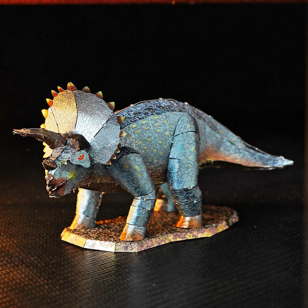 Kleurrijke metalen Triceratops volledig opgebouwd op een donkere ondergrond met warm zijlicht