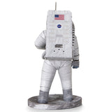 Een Apollo 11 astronaut in een wit pak staat op een grijs, rotsachtig oppervlak met een NASA-logo rugzak-ideaal als inspiratie voor jouw SlimSpul Apollo 11 astronaut - metalen bouwpakket model.