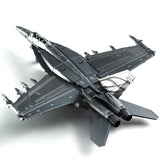 Het F-A-18 Hornet metalen bouwpakket van SlimSpul nederland b.v. is een modelbouw van een moderne straaljager in donkergrijs en zwart, getoond vanuit een bovenste achterhoek met zichtbare raketten en staartvinnen.