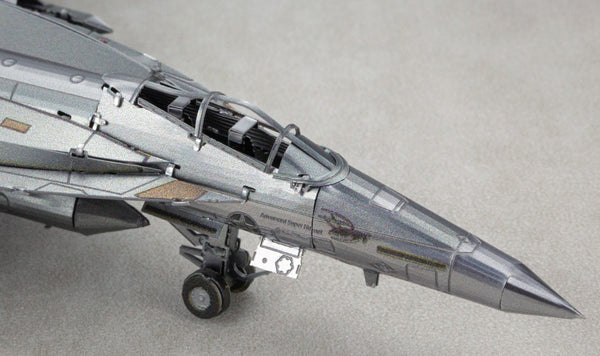 Close-up van de neus en cockpit van het F-A-18 Hornet metalen bouwpakket van SlimSpul nederland b.v., met gedetailleerde paneellijnen, landingsgestel en canopy op een effen lichtgekleurd oppervlak.