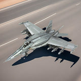 Een zilveren F-A-18 Hornet metalen bouwpakket van SlimSpul nederland b.v., uitgerust met raketten en bommen, taxiet over een zonovergoten baan en werpt een scherpe schaduw op het asfalt.