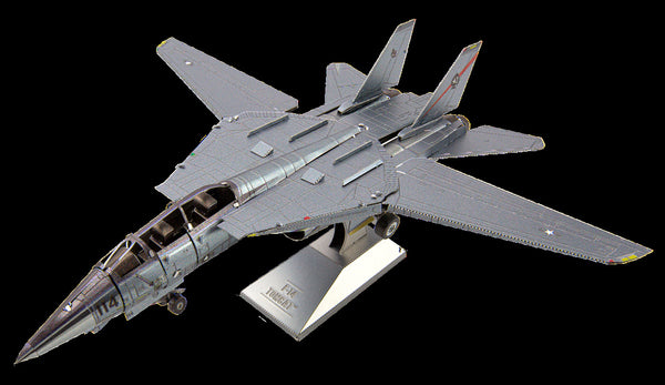 Het SlimSpul nederland b.v. F-A-18 Hornet metalen bouwpakket is een grijze modelbouw van een marine-straaljager met dubbele staarten en beweegbare vleugels, op een standaard en schuin van bovenaf bekeken.