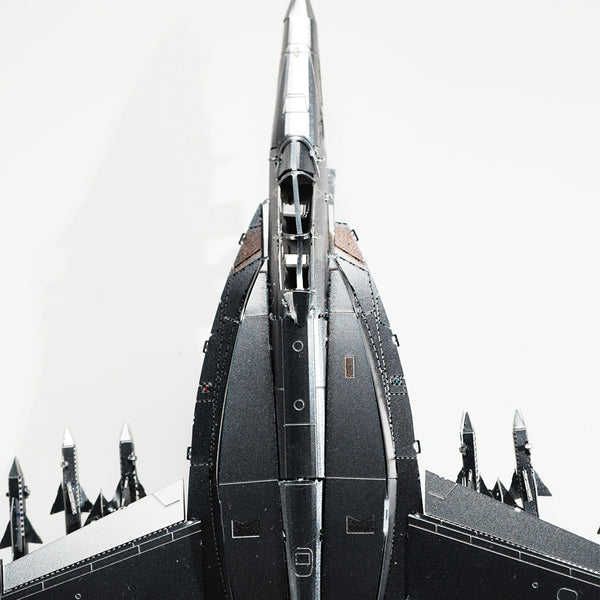 Bovenaanzicht van een SlimSpul nederland b.v. F-A-18 Hornet metalen bouwpakket model met raketten onder de vleugels, weergegeven op een effen witte achtergrond.