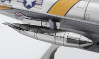 Close-up van het F-86 Sabre metalen bouwpakket van SlimSpul nederland b.v., met een metalen externe brandstoftank onder de vleugel, gedetailleerde paneellijnen en een deel van de U.S. Air Force-insigne.