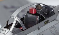 Close-up van het F-86 Sabre metalen bouwpakket van SlimSpul nederland b.v., met een gedetailleerde cockpit met realistische grijze en rode stoelen, bedieningspanelen, gestructureerde oppervlakken en een open kap die het interieur onthult.