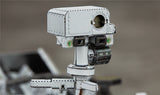 Een close-up van een verweerde, doosachtige robotkop met sensoren en camera's, zoals de Mars Rover & Helicopter Metalen Bouwpakket - Ruimtevaart Exploratie Set van SlimSpul nederland b.v., met de kenmerken gemarkeerd tegen een onscherpe achtergrond.