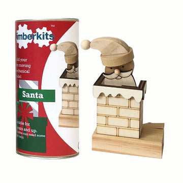 Gebouwde Timberkits Santa die uit een houten schoorsteen opduikt naast de cilindervormige bouwpakketverpakking