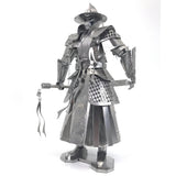 Het Imperial Guard Ming Dynasty Metalen Bouwpakket van SlimSpul nederland b.v. is een zilveren metalen model dat een Chinese middeleeuwse gepantserde krijger voorstelt met een breedgerande hoed, gedetailleerd harnas en een versierd zwaard, tegen een witte achtergrond.