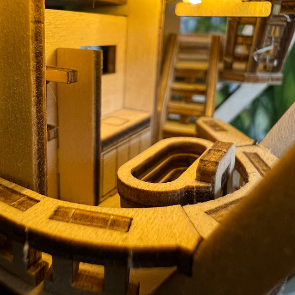 Close-up van de houten miniatuurkeuken Horizons Edge van Tiny Treehouses Europe, met gedetailleerde kastjes, aanrechten en gootsteen, allemaal warm verlicht om een gezellige en uitnodigende sfeer te creëren.