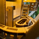 Close-up van de houten miniatuurkeuken Horizons Edge van Tiny Treehouses Europe, met gedetailleerde kastjes, aanrechten en gootsteen, allemaal warm verlicht om een gezellige en uitnodigende sfeer te creëren.