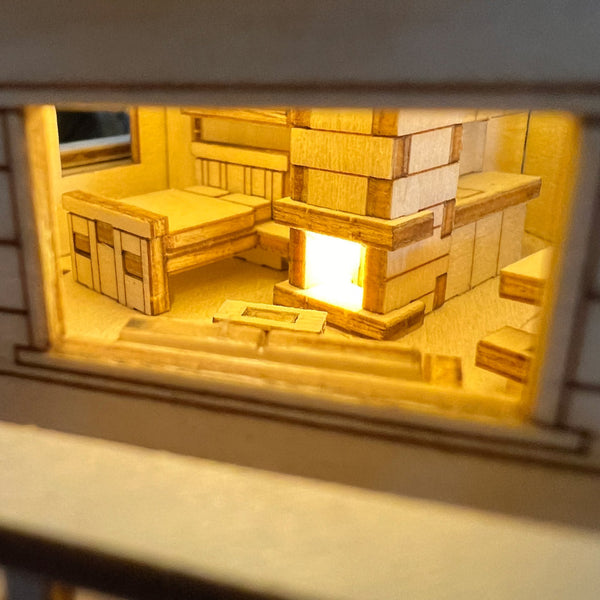 Een close-up door een raam onthult het gloeiende interieur van het Woodland Outpost DIY modelbouwpakket van Tiny Treehouses Europe, compleet met gedetailleerde meubels, LED-verlichting en een gezellige open haard - waardoor deze betoverende boomhut tot leven komt.