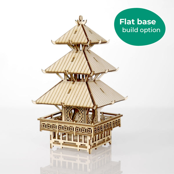De Tempel van Sereniteit van Tiny Treehouses Europe is een doe-het-zelf houten modelbouwpakket met een pagode met meerdere verdiepingen en gedetailleerde leuningen. Afgebeeld op een witte achtergrond, staat er op een groen label in de hoek, "Flat base build option".