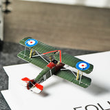 Het Sopwith Camel jachtvliegtuig metalen bouwpakket van SlimSpul nederland b.v. is een gedetailleerd modelbouw vliegtuig in vintage groen met Britse roundels, rode en witte accenten op neus en staart, gezien van boven op een witte ondergrond.