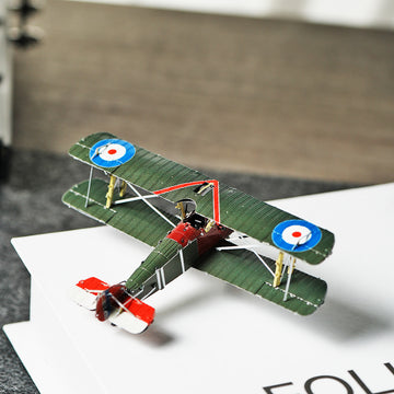 Het Sopwith Camel jachtvliegtuig metalen bouwpakket van SlimSpul nederland b.v. is een gedetailleerd modelbouw vliegtuig in vintage groen met Britse roundels, rode en witte accenten op neus en staart, gezien van boven op een witte ondergrond.