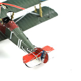 Close-up van het Sopwith Camel jachtvliegtuig metalen bouwpakket van SlimSpul nederland b.v., een iconisch WOI jachtvliegtuig met groene body, rode accenten en rood-wit-blauwe staartvin op een witte achtergrond.