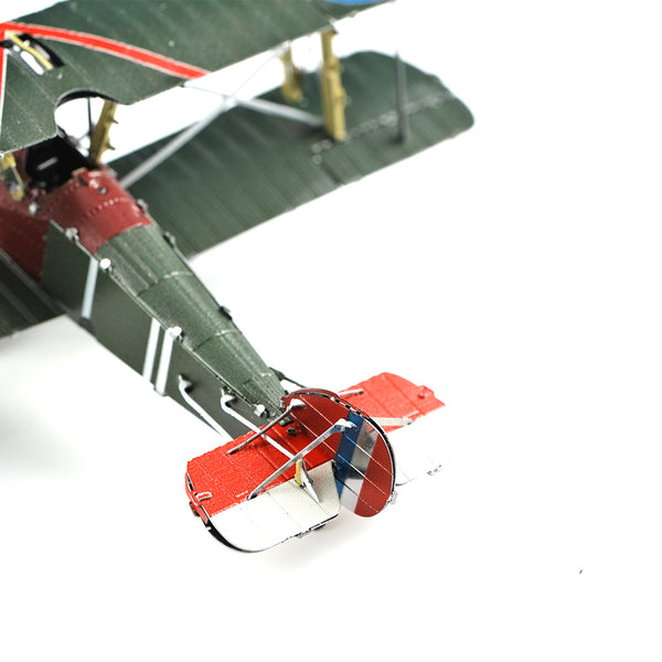 Close-up van het Sopwith Camel jachtvliegtuig metalen bouwpakket van SlimSpul nederland b.v., een iconisch WOI jachtvliegtuig met groene body, rode accenten en rood-wit-blauwe staartvin op een witte achtergrond.