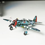 Het P-47 Thunderbolt metalen bouwpakket van SlimSpul nederland b.v. is een gedetailleerd miniatuurmodel met camouflage, US Air Force embleem, HV-A markeringen, geel propellerpunt en rode staart, gepresenteerd op een witte ondergrond.