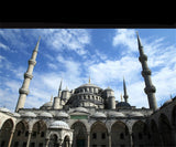 De afbeelding toont de Blauwe Moskee Istanbul Metalen Bouwpakket van SlimSpul nederland b.v.-een architectonische miniatuur geïnspireerd op de iconische Ottomaanse moskee met centrale koepel, kleinere koepels en hoge minaretten onder een blauwe lucht.