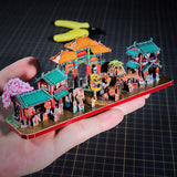 Chinees straatfestival metalen diorama op een hand als schaalreferentie met tempelpoorten en optocht