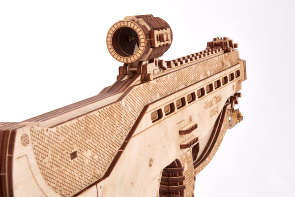 Een close-up van het WoodTrick Assault Gun USG-2 - Machinepistool Bouwpakket van WoodTrick, met gedetailleerde gegraveerde patronen op het vizier en de loop, tegen een effen witte achtergrond.