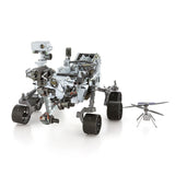 De SlimSpul nederland b.v. Mars Rover & Helicopter Metalen Bouwpakket - Ruimtevaart Exploratie Set bestaat uit een gedetailleerde rover met grote wielen, een cameramast en een helikopterdrone met zonnepanelen, die een indrukwekkende weergave vormen op een witte achtergrond.