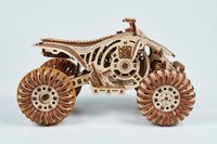 De WoodTrick Cross Quad Bike - Quad bouwpakket voor volwassenen van WoodTrick is een gedetailleerd houten model ATV met grote, gesegmenteerde wielen, werkende en fijne uitsnijdingen, getoond tegen een witte achtergrond.