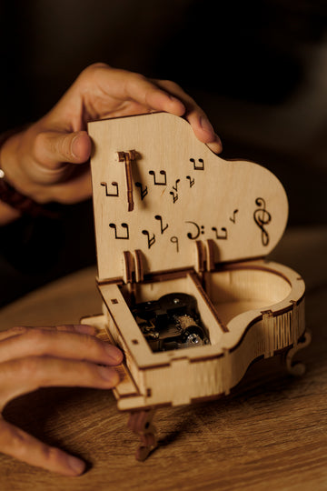WoodTrick Grand Piano in handen met geopende klep en zicht op het mechanische muziekdoosje
