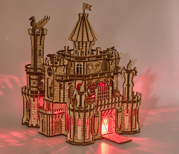 Verlicht WoodTrick Dragon Castle met rood licht door de poort en vensters en geopende ophaalbrug