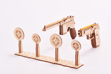 Complete WoodTrick Set of Guns met twee houten elastiekpistolen en vier ronde schietschijven op witte achtergrond