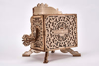 Het WoodTrick Fairy Theater - Houten Theater Bouwpakket is een decoratieve, lasergesneden houten kist met sierlijke patronen, staand op vier gebogen poten, voorzien van een slinger en de woorden WoodTrick - perfect als mechanische modelbouw of houten puzzel voor volwassenen.