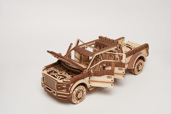 De WoodTrick Full-size Pickup Truck - Amerikaans Autopakket van WoodTrick is een houten modelauto met open deuren en motorkap, perfect als bouwpakket voor volwassenen. Geplaatst op een eenvoudige witte achtergrond.
