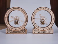 Twee WoodTrick Kinetische Klok: Modern - Houten Klok Bouwpakket worden naast elkaar getoond. Op de linker staan tijdlabels, op de rechter dierenriemsymbolen. Beide klokken met zichtbare tandwielen hebben gedetailleerde uitgesneden ontwerpen van WoodTrick.