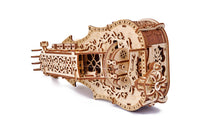 Het WoodTrick Lyra da Vinci - Houten Muziekinstrument Bouwpakket van WoodTrick is een sierlijk houten mechanisch model, geïnspireerd door Leonardo da Vinci, met tandwielen en bloemmotieven, die lijken op een snaarinstrument. Tegen een witte achtergrond.