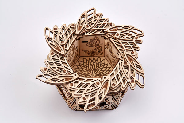 Het WoodTrick Mystery Flower - Sieradendoos Bouwpakket van WoodTrick is een decoratieve houten sieradendoos met ingewikkelde uitgesneden bladmotieven en gegraveerde vlinder- en bloemmotieven - een uniek geschenk en stijlvol opbergmeubel.