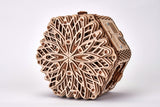 Het WoodTrick Mystery Flower - Sieradendoos Bouwpakket van WoodTrick is een lasergesneden, zeshoekig houten sieradendoosje met een bloemmotief - een ideaal cadeau voor liefhebbers van vakmanschap, hier afgebeeld tegen een effen witte achtergrond.