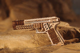 Complete WoodTrick Defenders Gun op een rotsachtige ondergrond met het houten pistoolmodel volledig in beeld