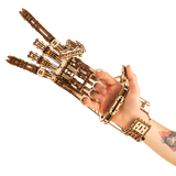 WoodTrick Cyber Hand gedragen om een menselijke hand met zichtbare vingerringen en polsbevestiging