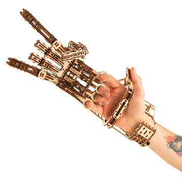 WoodTrick Cyber Hand gedragen om een menselijke hand met zichtbare vingerringen en polsbevestiging