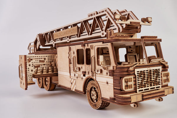 Het WoodTrick Rescue Firetruck - Houten Brandweerauto Bouwpakket van WoodTrick bevat laser-gesneden, interlockende stukken en heeft een ladder op het dak plus een open zijdeur die uitrusting laat zien.