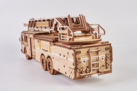 De WoodTrick Rescue Firetruck - Houten Brandweerauto Bouwpakket van WoodTrick, zorgvuldig samengesteld uit laser-gesneden stukken, is te zien met een ladder op het dak tegen een effen witte achtergrond.