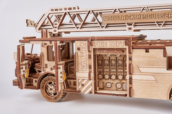 De WoodTrick Rescue Brandweerwagen - Houten Brandweerauto Bouwpakket is een gedetailleerd houten model met "FIRE DEPT" en "CAUTION" labels, gemonteerde ladder, tandwielen en ingewikkelde uitsparingen uit de WoodTrick RESCUE SERIES.
