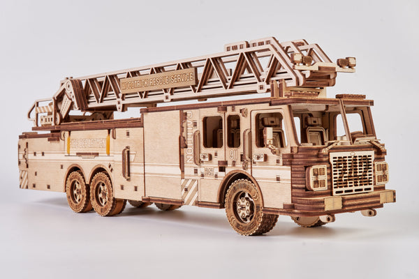 Een gedetailleerde WoodTrick Rescue Firetruck - Houten Brandweerauto Bouwpakket model met een verlengde ladder en "MODERN FIRE RESCUE SERVICE" label, tegen een effen witte achtergrond.