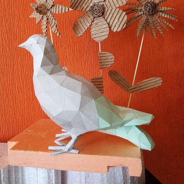 Gebouwde witte papieren duif op een plank voor een oranje wand met kartonnen bloemen