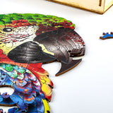 Een gedeeltelijk voltooide SlimSpul nederland b.v. Papegaai Houten Puzzel (A3 formaat) - Kleurrijk Vogel Figuurpuzzel, waarvan een stukje bij de snavel ontbreekt, toont levendige kleuren en een extra stukje dat op een wit vlak rust.