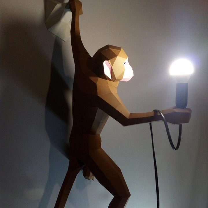 Grote papieren aap aan de muur met LED-lamp op zijn hand
