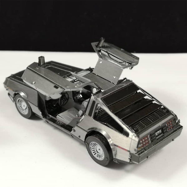 De DeLorean Tijdmachine Metalen Bouwpakket van SlimSpul nederland b.v. is een gedetailleerd Back to the Future automodel met openstaande vleugeldeuren, ideaal voor fans en verzamelaars. Geplaatst tegen een zwart-witte achtergrond.