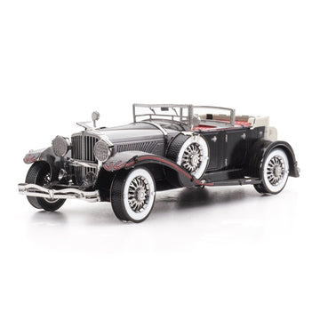 De 1935 Duesenberg Metalen Bouwpakket - Klassieke Oldtimer Auto van SlimSpul nederland b.v. toont een zwarte oldtimer met chroomdetails, whitewall-banden, beige interieur en zijmontage reservewielen op een witte achtergrond.
