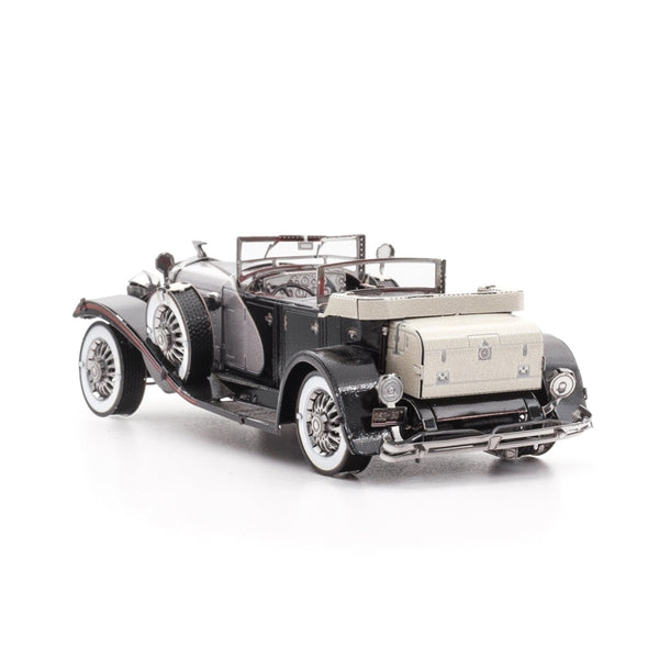 Een gedetailleerde metalen modelauto van de 1935 Duesenberg Metalen Bouwpakket - Klassieke Oldtimer Auto van SlimSpul nederland b.v., een zwarte klassieke cabriolet met beige kofferkoffer, whitewall banden en chroomaccenten op witte achtergrond.